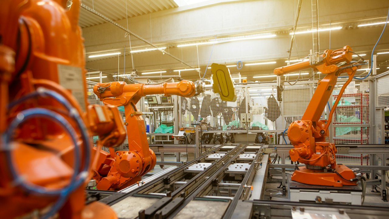 Orangefarbene Industrieroboter in einer Fabrikhalle